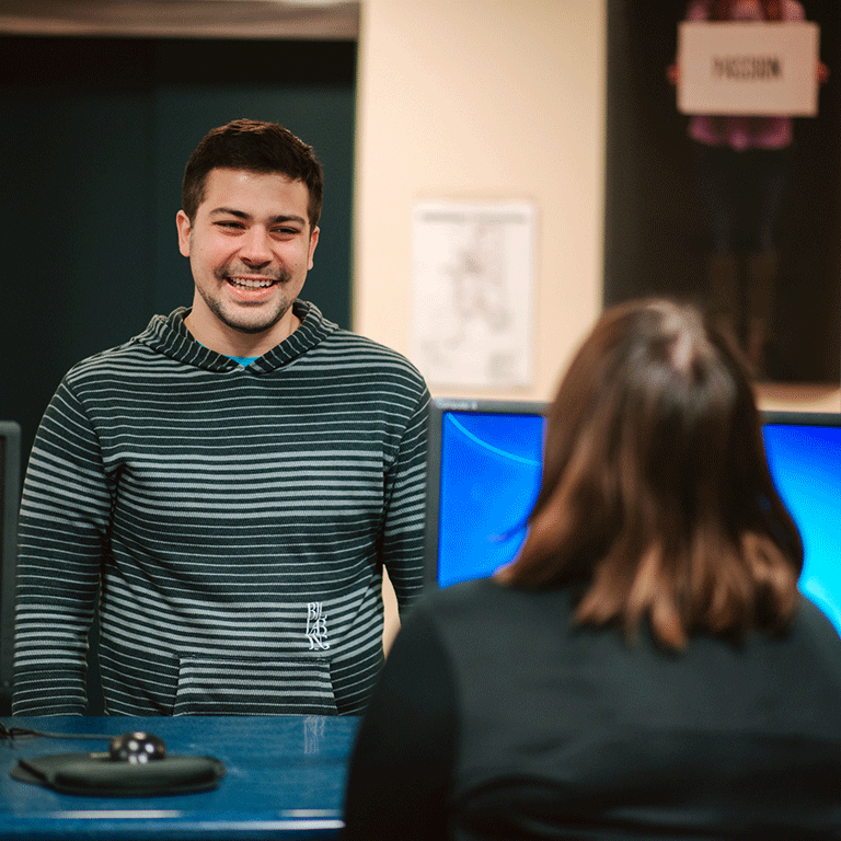 Student standing at the Bepko Learning Center helpdesk.